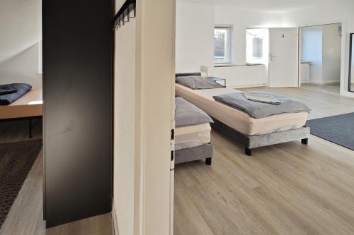 a room with three beds and a room with a hallway at Gemeinschaftswohnung mit privaten Zimmern in Diepholz