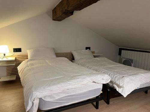 a bedroom with two beds with white sheets at Apartamento centro de Puigcerda in Puigcerdà