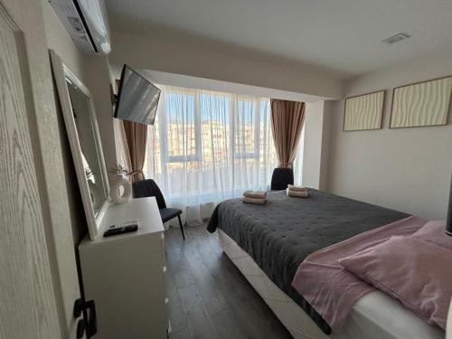 ein Schlafzimmer mit einem Bett und einem großen Fenster in der Unterkunft Mateo in Ruse