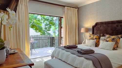 a bedroom with a large bed and a balcony at Upper Classic in Clarens
