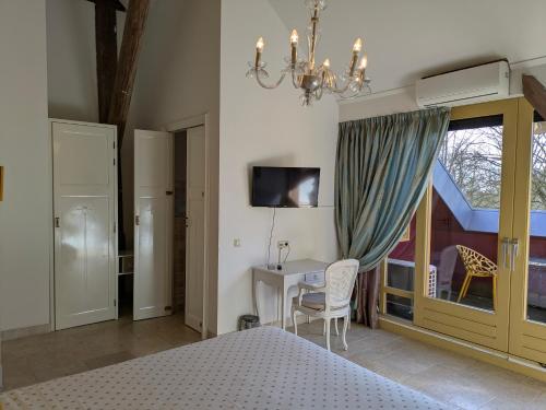 a bedroom with a bed and a table and a chandelier at Boutique Hotel Westerlee in Westerlee