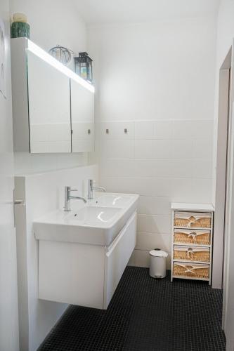 a white bathroom with a sink and a mirror at Downtown Zurich - Large, quiet private room "Alps" in homestay - Enge station - Lake & City - For 1 person in Zurich