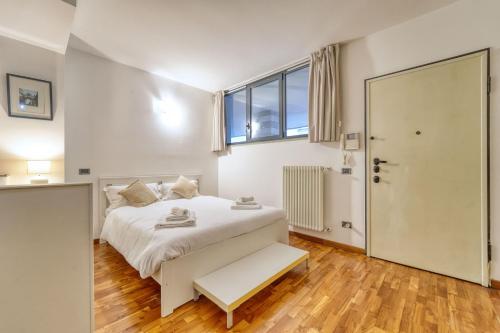 a bedroom with a white bed and a large window at Sergio's house in Como