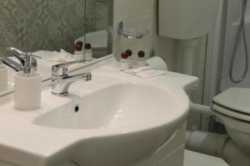 a bathroom with a white sink and a toilet at B e B Madonna della Via in Caltagirone