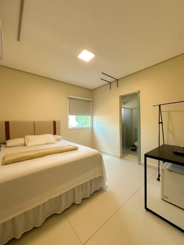 ein Schlafzimmer mit einem großen Bett und einem Schreibtisch in der Unterkunft TERESINA HOTEL in Teresina