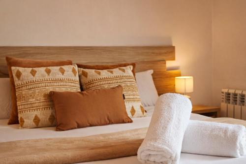a bedroom with a large bed with pillows at Allotjaments Vall de Muntanyes in Molló