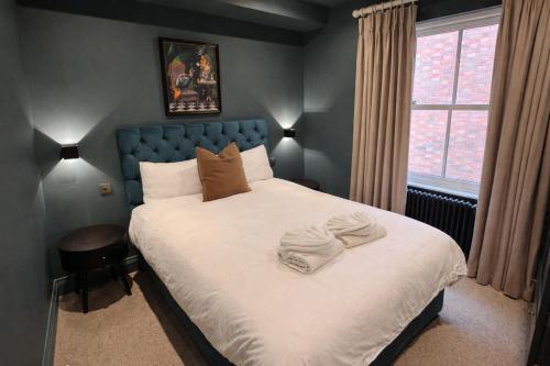 a bedroom with a bed with towels on it at Romeo's Arch - Luxury Apartment with Private Parking in Stratford-upon-Avon