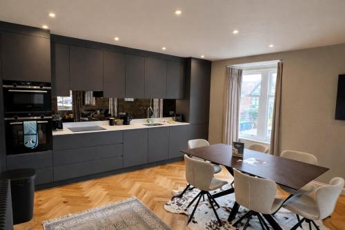 a kitchen with a wooden table and a kitchen with a counter at Romeo's Arch - Luxury Apartment with Private Parking in Stratford-upon-Avon