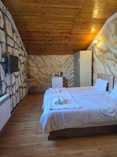 a bedroom with two beds and a stone wall at Hirmas boutique hotel in Tbilisi City