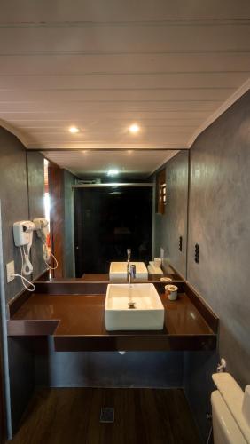 a bathroom with a sink and a large mirror at Anexo à Pousada WindJeri in Jericoacoara