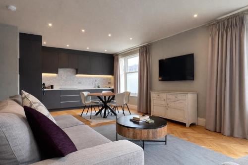 a living room with a couch and a table at Macbeths Corner - Luxury Apartment with Private Parking in Stratford-upon-Avon