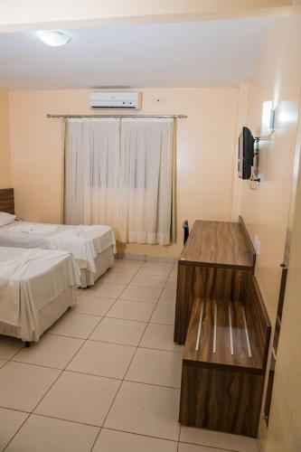 a hotel room with two beds and a window at Requinte Hotel in Altamira