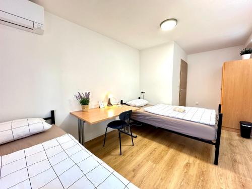 a room with two beds and a desk in it at Rookos rooms in Ljubljana