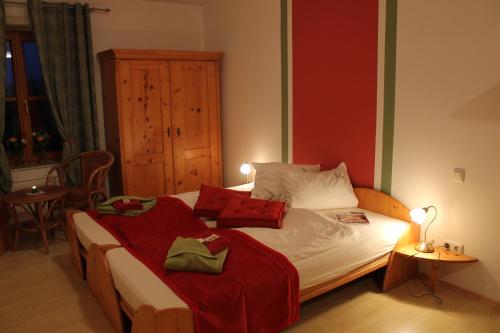 a bedroom with a large bed with red and white pillows at Pihringer's Moststub'n in Amstetten