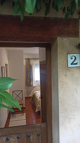 a view of a room with a bed and a mirror at Las Lucías, experiencias de ecoturismo in Navatrasierra
