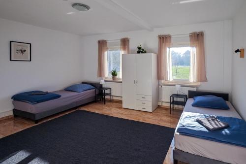 a bedroom with two beds and a white cabinet at Apartment 1 in Diepholz