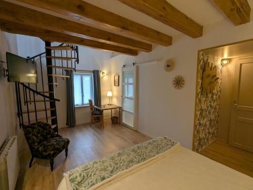 a bedroom with a bed and a chair and a desk at Les Chardonnerets in Villemandeur