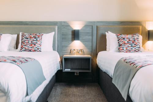 a hotel room with two beds and a side table at Armagh City Hotel in Armagh