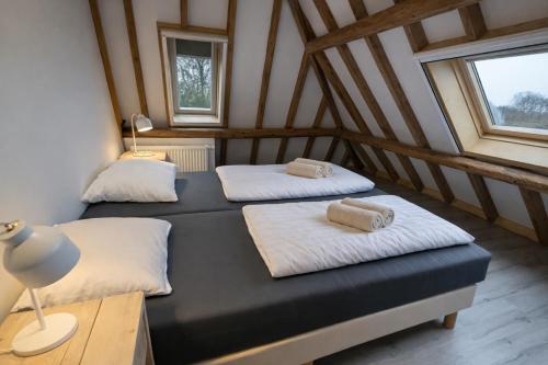 two beds in a room with two windows at Ballumerhoeve Skip lodge in Ballum