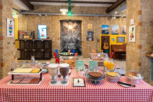 a table with food on a red and white checked table cloth at Ostello Bello Napoli in Naples
