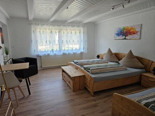 a bedroom with two beds and a table in it at Farmhaus in Ravensburg