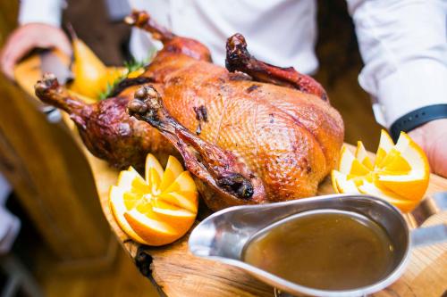 a turkey on a cutting board with oranges and a spoon at Hotel Gdańsk Boutique in Gdańsk
