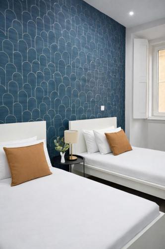 a bedroom with two beds and a blue wall at Velvet Prime Stay in Lisbon