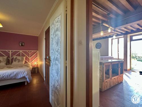 a bedroom with a bed and a room with a window at Le Refuge in Liernais