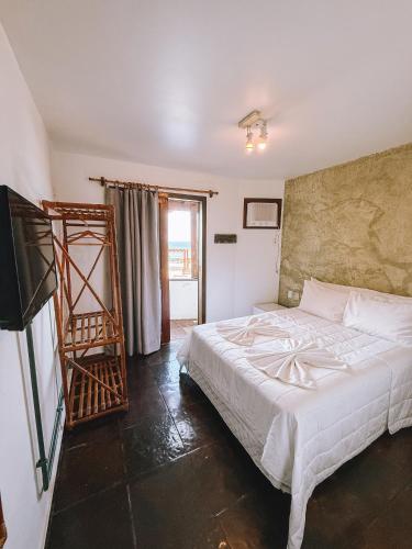 a bedroom with a white bed and a ladder at Acuario Pousada in Arraial do Cabo
