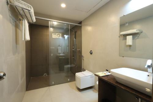 a bathroom with a shower and a sink and a toilet at Hotel Sidh Vedantha in Patna