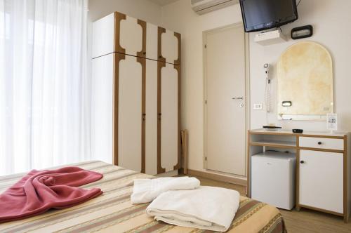 a room with a bed with a sink and a mirror at Hotel Alba in Gabicce Mare
