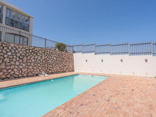 a swimming pool in front of a building at Sunset Heights in Langebaan