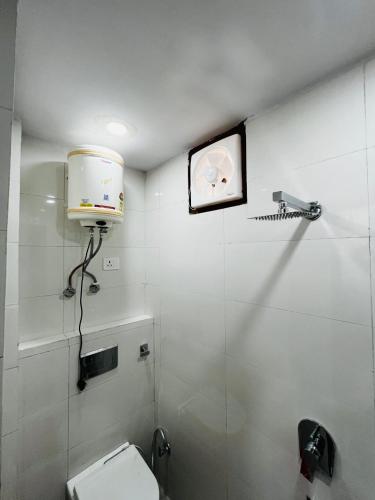 a bathroom with a toilet and a clock on the wall at Hotel Crystal Haven in New Delhi