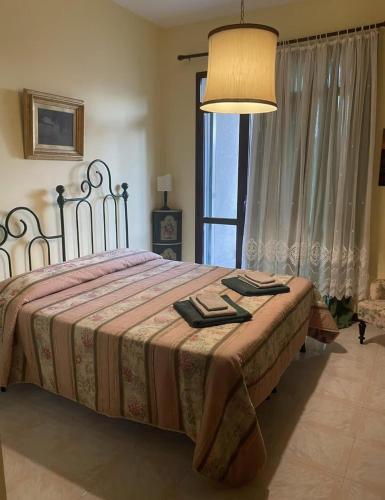 a bedroom with a bed with a lamp and a window at Lo studio di Gabriella in Bolsena