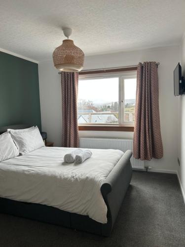 a bedroom with a bed with two towels on it at Hillview Portree Isle of Skye Self Catering House in Portree