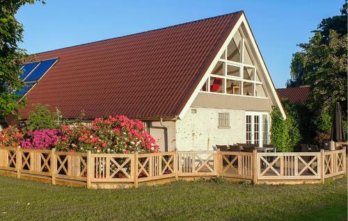 a large house with a wooden fence and flowers at Apartment Sønderskovhedevej in Langå