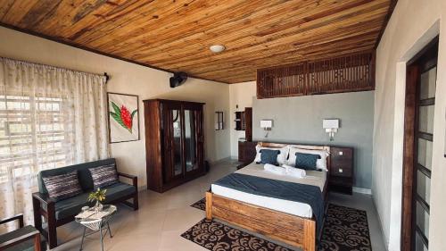 a bedroom with a bed and a wooden ceiling at Coconut Resort in Tuléar