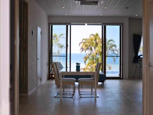 a dining room with a table and chairs and the ocean at YUTO Ishigakijima in Ishigaki Island