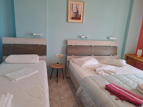 a bedroom with two beds and a table at Ground floor economy studio in karmiris studios in Zakynthos