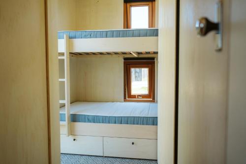 a room with two bunk beds and a window at Vakantiepark De Klepperstee in Ouddorp