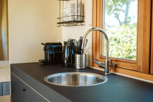 a kitchen counter with a sink and a window at Vakantiepark De Klepperstee in Ouddorp