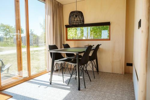 a dining room with a table and black chairs at Vakantiepark De Klepperstee in Ouddorp