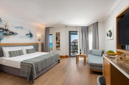 a bedroom with a bed and a tv and a chair at Limak Limra Hotel & Resort Kemer - Kids Concept in Kemer