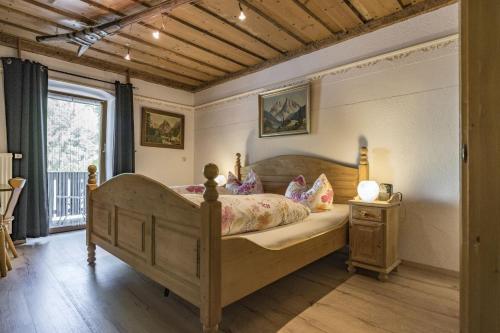 a bedroom with a wooden bed and a window at Pension Lex in Bad Reichenhall