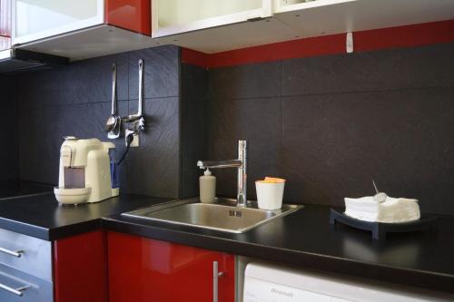 una cucina con lavandino e armadietti rossi di Apartamento Centro de Lisboa a Lisbona