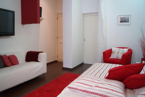 un soggiorno con divano bianco e sedie rosse di Apartamento Centro de Lisboa a Lisbona