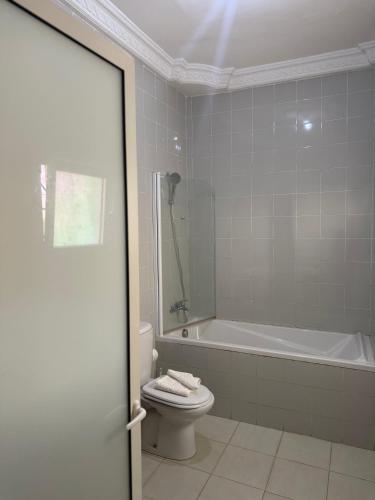 a bathroom with a tub and a toilet and a sink at MAG Palace Hotel in Bissau