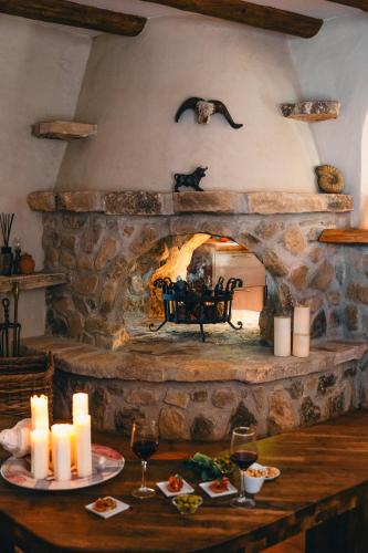 a stone fireplace with a table with food and candles at Villa Mistral Montiboli by Buccara in Villajoyosa