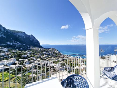 ein Balkon mit Stühlen und Meerblick in der Unterkunft Domus Capri in Capri