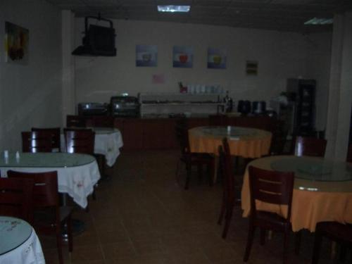 a dining room with tables and chairs with white table cloth at GreenTree Inn Ji‘nan Shanda Road Business Hotel in Jinan